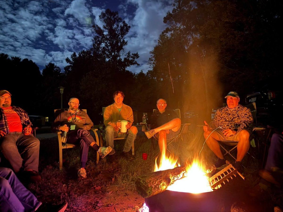 Friends sitting around a campfire at night